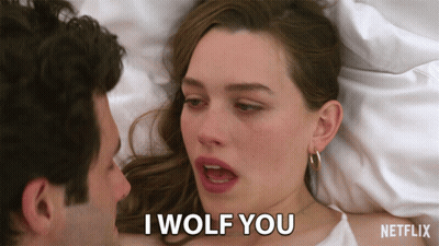 A Man And A Woman Are Laying In Bed And The Woman Is Saying I Wolf You GIF