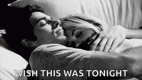 A Man And A Woman Are Laying In Bed Hugging Each Other And The Man Is Saying `` Wish This Was Tonight '' . GIF