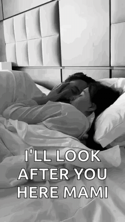 A Man And A Woman Are Laying In Bed Kissing . GIF