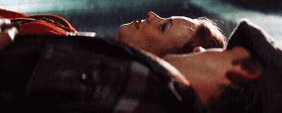 A Man And A Woman Are Laying Next To Each Other On The Floor . GIF