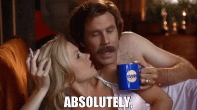 A Man And A Woman Are Laying On A Couch And The Woman Is Holding A Mug That Says Absolutely On It . GIF