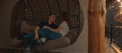 A Man And A Woman Are Laying On A Couch With The Sun Shining Through Them GIF