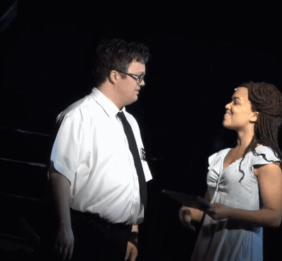 A Man And A Woman Are Looking At A Tablet GIF