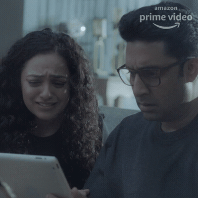 A Man And A Woman Are Looking At A Tablet With An Amazon Prime Video Logo In The Background GIF