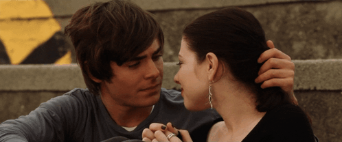 A Man And A Woman Are Looking At Each Other GIF