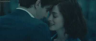 A Man And A Woman Are Looking At Each Other And Kissing . GIF