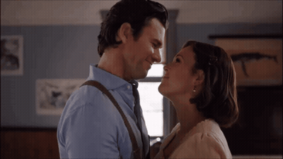 A Man And A Woman Are Looking At Each Other And Smiling GIF