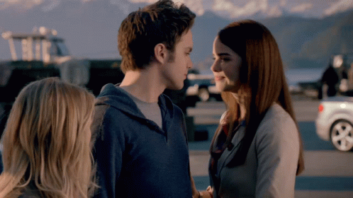 A Man And A Woman Are Looking At Each Other And Smiling GIF