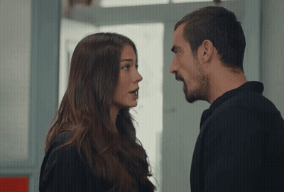A Man And A Woman Are Looking At Each Other And Talking GIF