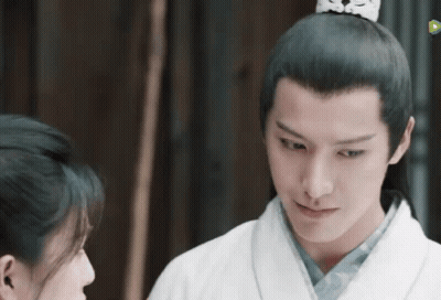 A Man And A Woman Are Looking At Each Other And The Man Is Wearing A Crown On His Head . GIF