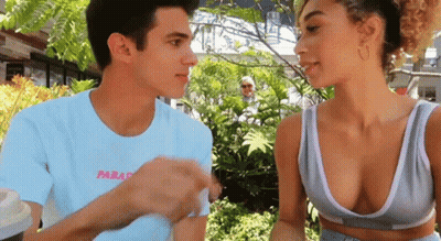 A Man And A Woman Are Looking At Each Other And The Man Is Wearing A Shirt That Says Paradis GIF