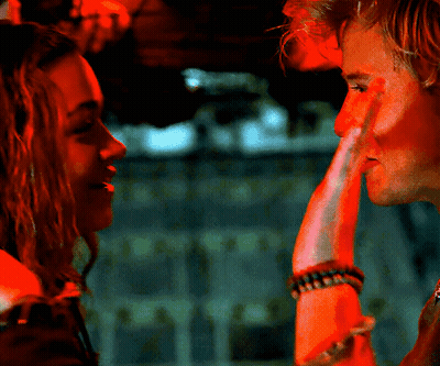 A Man And A Woman Are Looking At Each Other And The Woman Has A Bracelet On Her Wrist GIF