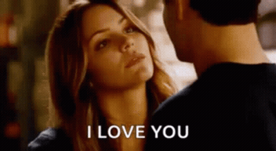 A Man And A Woman Are Looking At Each Other And The Woman Is Saying I Love You . GIF