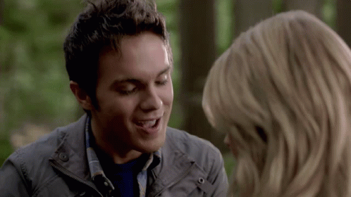 A Man And A Woman Are Looking At Each Other And The Woman Is Smiling GIF