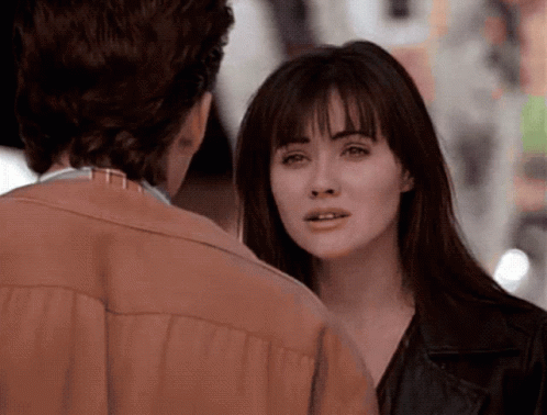 A Man And A Woman Are Looking At Each Other And The Woman Is Wearing A Brown Jacket GIF