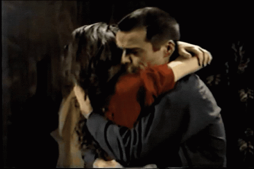 A Man And A Woman Are Looking At Each Other And The Woman Is Wearing A Ring On Her Finger GIF