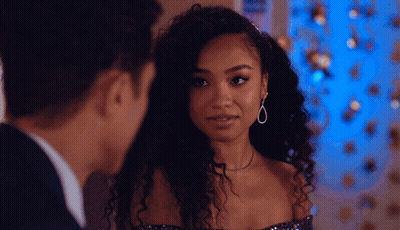 A Man And A Woman Are Looking At Each Other And The Woman Is Wearing Earrings GIF