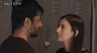 A Man And A Woman Are Looking At Each Other And The Words Zip It Up Are Visible GIF