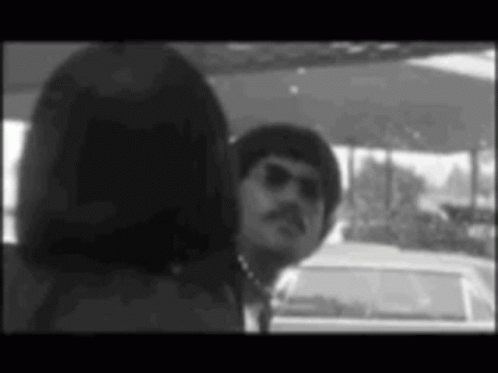 A Man And A Woman Are Looking At Each Other In A Car . GIF
