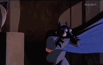 A Man And A Woman Are Looking At Each Other In A Dark Room . GIF