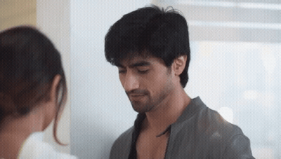 A Man And A Woman Are Looking At Each Other In A Room GIF