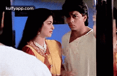 A Man And A Woman Are Looking At Each Other In A Room . GIF