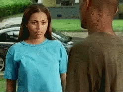 A Man And A Woman Are Looking At Each Other In Front Of A Car GIF