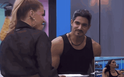 A Man And A Woman Are Looking At Each Other In Front Of A Mirror GIF