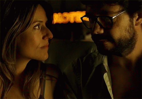 A Man And A Woman Are Looking At Each Other In Front Of A Sign That Says Motel GIF
