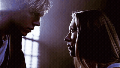 A Man And A Woman Are Looking At Each Other . GIF