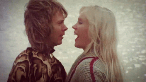 A Man And A Woman Are Looking At Each Other GIF