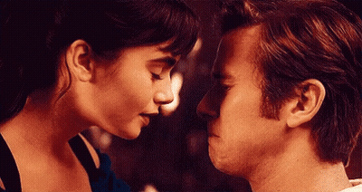 A Man And A Woman Are Looking At Each Other 'S Faces . GIF