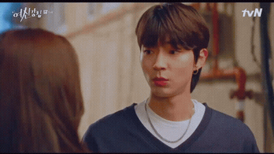 A Man And A Woman Are Looking At Each Other . The Man Is Wearing A Necklace . GIF