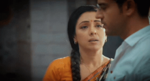 A Man And A Woman Are Looking At Each Other . The Woman Is Wearing A Braided Hairstyle . GIF