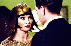 A Man And A Woman Are Looking At Each Other . The Woman Is Wearing A Helmet . GIF