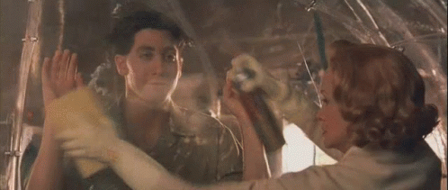 A Man And A Woman Are Looking At Each Other Through A Window In A Plane . GIF