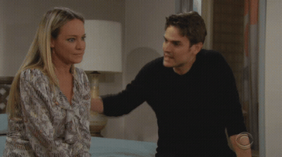 A Man And A Woman Are Looking At Each Other With A Cbs Logo On The Bottom Left GIF