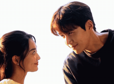 A Man And A Woman Are Looking At Each Other With A White Background GIF