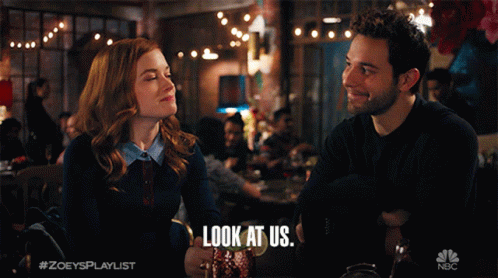 A Man And A Woman Are Looking At Each Other With The Caption Look At Us GIF