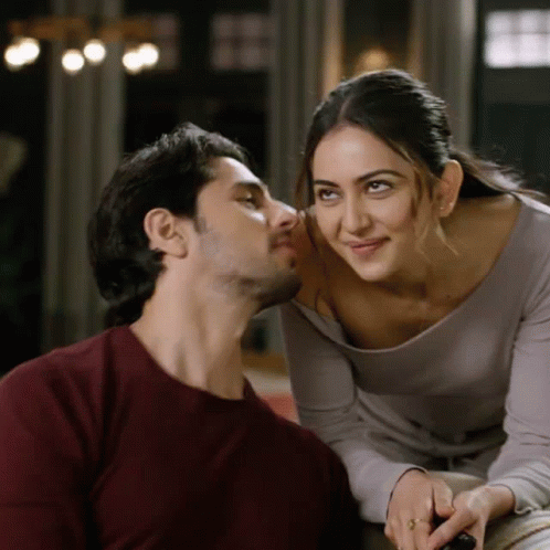 A Man And A Woman Are Looking At Each Other With The Woman Smiling GIF