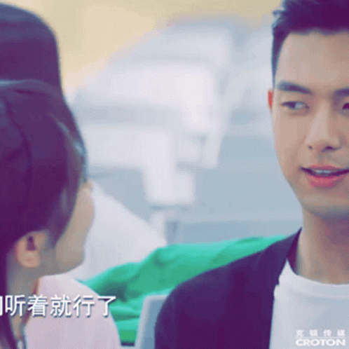 A Man And A Woman Are Looking At Each Other With The Word Croton On The Bottom Right GIF
