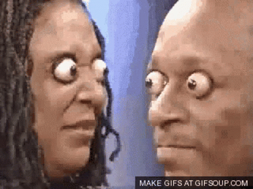 A Man And A Woman Are Looking At Each Other With Their Eyes Wide Open .. GIF
