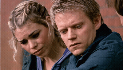 A Man And A Woman Are Looking At Something Together GIF
