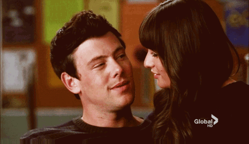 A Man And A Woman Are Looking Into Each Other 'S Eyes With A Global Hd Advertisement In The Background GIF