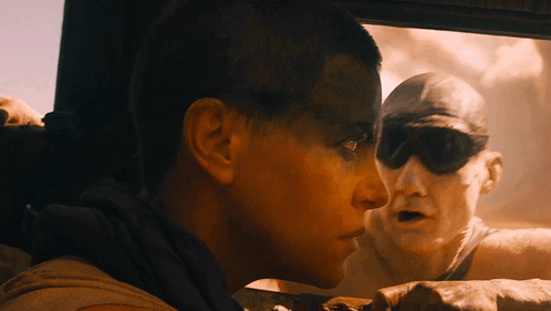 A Man And A Woman Are Looking Out A Car Window GIF