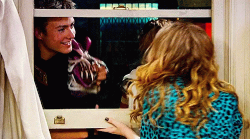 A Man And A Woman Are Looking Out A Window And The Man Is Smiling GIF