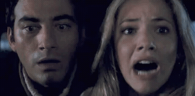 A Man And A Woman Are Looking Scared In A Car . GIF