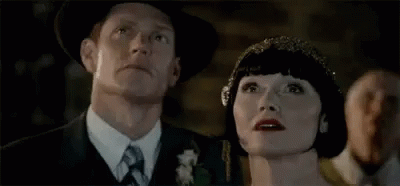A Man And A Woman Are Looking Up At The Sky . GIF