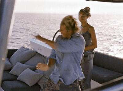 A Man And A Woman Are On A Boat With A Box That Says ' A ' On The Side GIF