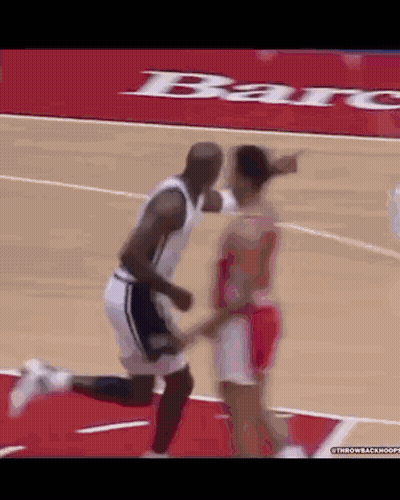 A Man And A Woman Are Playing Basketball On A Court With A Bar Advertisement In The Background .. GIF